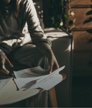 A woman working through papers and a laptop at home